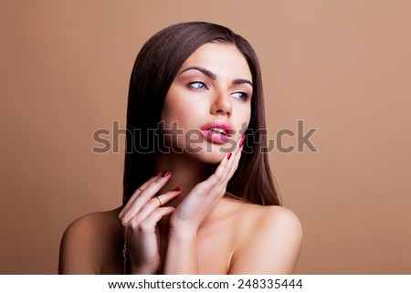 Beauty face closeup portrait with clean and fresh elegant lady. Woman with dark   straight  hair and sexy lips posing on   brown background.