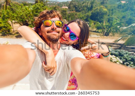 Happy lovers,  attractive woman and man traveling  in tropical island enjoying romance.  Attractive couple  making selfie, smiling and have fun together.
