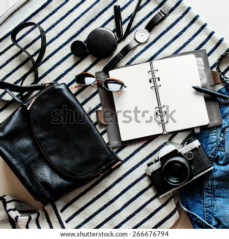 Outfit of young stylish  woman. Essentials for modern young lady. Jeans, note book, sweatshirt, nail polish, lipstick, lip pencil, powder, glasses, pen, belt, leather bag.