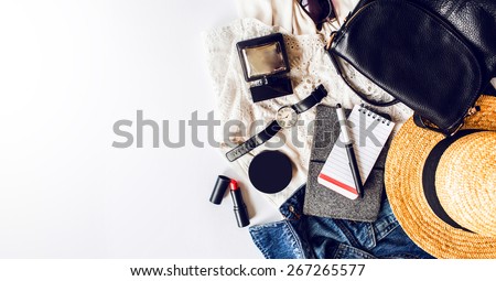 Casual  trendy outfit of young stylish woman. Essentials for modern   lady. Jeans jacket , note book,  white dress ,lipstick,powder, pen, leather bag, straw hat, perfume .