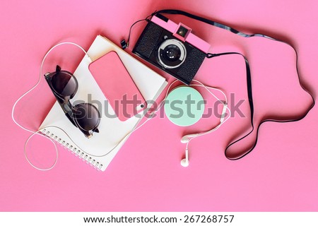 Outfit of student, teenager, young woman or girl . Overhead of essentials for modern young person. Different objects on  pink background . Pastel  tender colors. Area view.