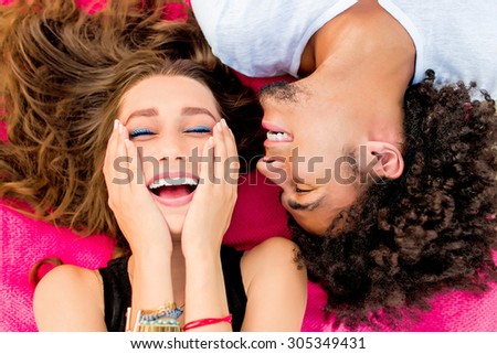 Young happy couple  posing in hot sunny summer day on the beach. Couple in love having fun and enjoying time together.   Friends making grimace  and laughing .
