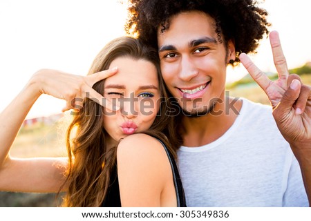 Outdoor portrait of  cheerful  young international couple shoes crazy  faces .  Friends having fun , emotional people, making self portrait.