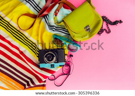 Outfit of student, teenager, young woman or girl . Overhead of essentials for modern young person. Different objects on pink background . Bright summer  colors. Area view.