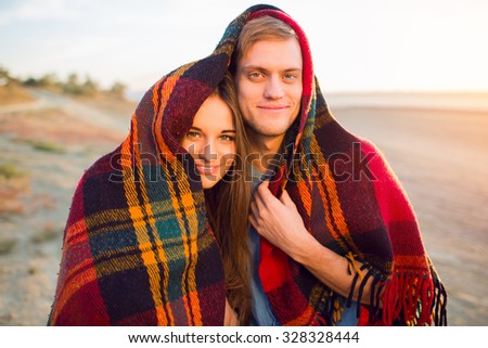 Lifestyle portrait of two romantic  young pretty people hugs and have  great time together. Cheerful couple in love have fun  and  laughing . Bright  evening golden colors.