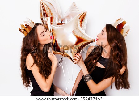 Two joyful pretty friends celebrating new year or birthday party, have fun, drink alcohol , dancing . Emotional faces. Couple sexy elegant women posing indoor studio portrait white background.