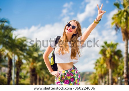 Lifestyle summer image of pretty blonde hipster woman with bag pack  traveling and enjoying  sightseers  in Barcelona, stylish fresh look, happy mood, sunny colors, travel concept, emotions.