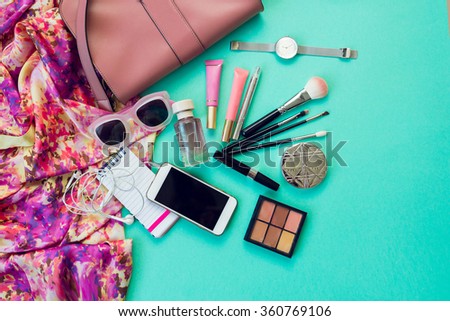 Top view of female fashion accessories for woman. Stylish sunglasses, bag, silver watch , lipstick, perfume. Pastel colors. Overhead of essentials for modern young person. Area view.