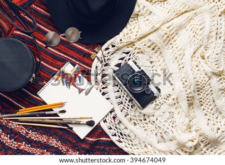 Objects top view  lifestyle essentials  of  artist girl or woman. Objects for painting, writing and sketching .Knitted sweater, bohemian stile. Retro vintage film camera,  art brushes.