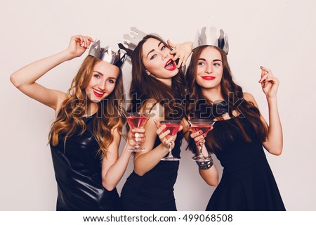 Crazy party time of three  beautiful  stylish  women in elegant casual black outfit  celebrating  new year, birthday , having fun, dancing,drinking alcohol  cocktails .
