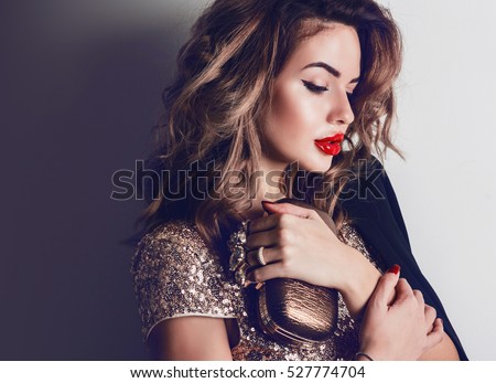 Close up portrait of elegant luxurious woman in trendy gold sequin party dress . Elegant wavy hairstyle, bright make up, red lips.