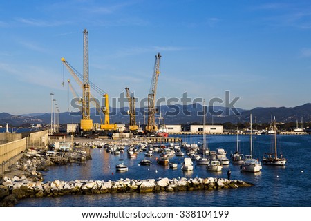 Panoramic view of a commercial port in a sunny morning with mountains in the background