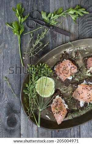 starters with salmon butter seeds lemon and green herbs on complete rye bread