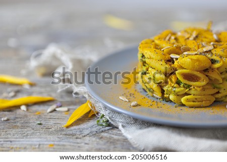 summer flowers pasta with seeds and petals flowers and yellow spices on rustic background