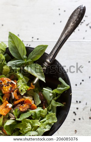 alternative vegan salad with basil, carrots chips, walnuts and seeds in japanese bowl