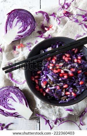 sauteed purple cabbage and pomegranate grains  on bowl with japanese chopsticks on rustic table