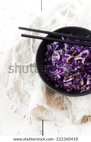 sauteed purple cabbage on bowl with japanese chopsticks on white rustic table