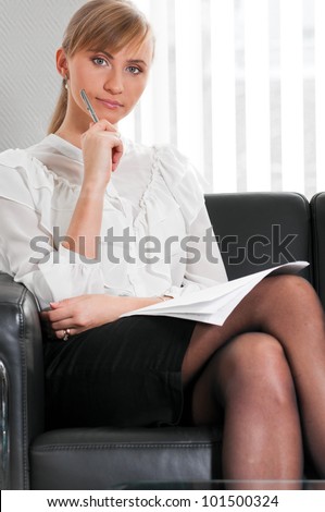 young business woman is sitting on sofa at modern office