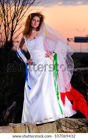 young woman in wedding dress at sunset