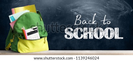 Back to school shopping baackpack. Accessories in student bag against chalkboard