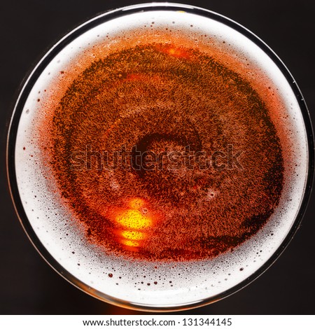 glass of fresh lager beer on black table