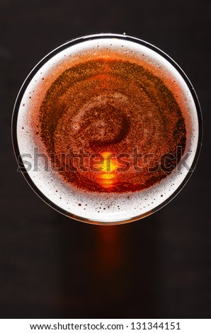 glass of fresh lager beer on black table