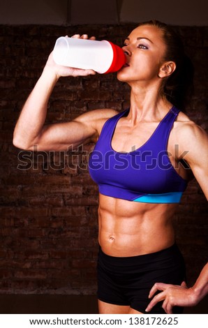 strong woman is drinking sports nutrition - stock photo