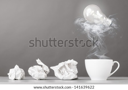 creative process. crumpled wads and cup on gray