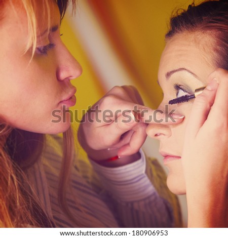 makeup artist is applying cosmetics on model face