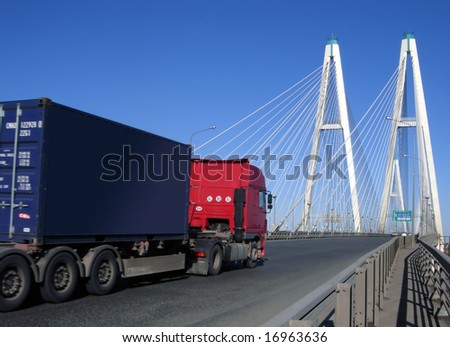 blue-red truck driving on cable-braced bridge