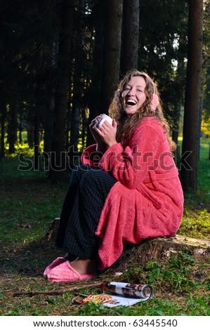 happy woman is taking breakfast at forest in undress
