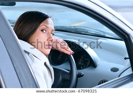 beautiful sensual woman put her head on steering wheel and looking back at camera