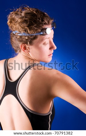 back of a elegant woman swimmer on blue background