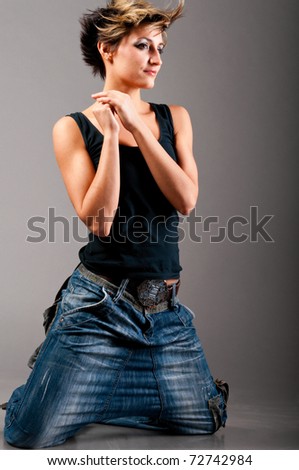 sexy fashionable knelt down woman wearing black tank top and jeans