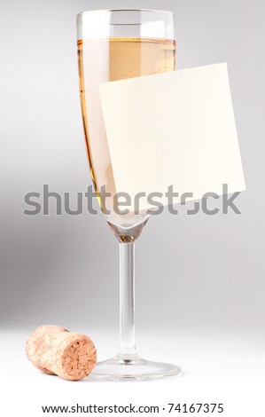 champagne glass with blank sticky note and cork