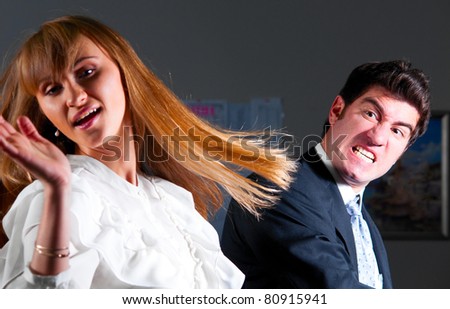 angry businessman is slapping across the businesswoman\'s face
