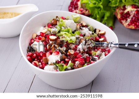 Healthy salad with pomegranate seeds, almond, feta cheese and black rice