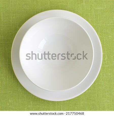Blank white round ceramic plates isolated on background green linen tablecloth
