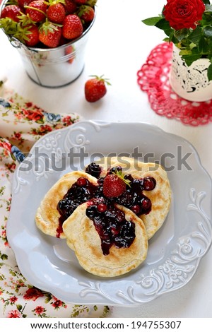 Pancakes with berry topping with fresh berries on a grey plate. Selective focus