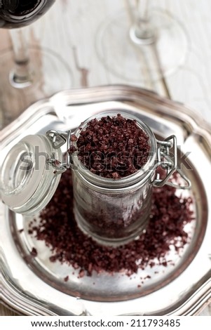 Red wine sea salt in a jar with glasses of wine. Selective focus, shallow depth of field