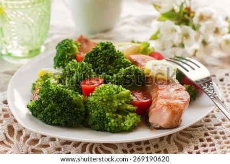 Salmon teriyaki served with broccoli, tomatoes and lemon. Selective focus on the fish
