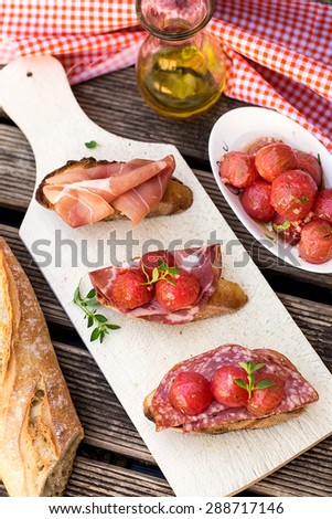 Italian ham dry cured prosciutto on bread toast with coppa and salami. Selective focus