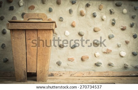 The old wooden bin at cement wall decorate stone