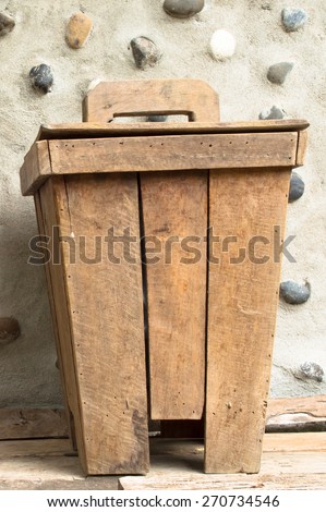 The old wooden bin at cement wall decorate stone