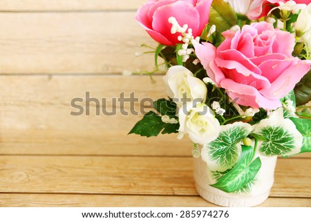 Pink roses against a wood wall