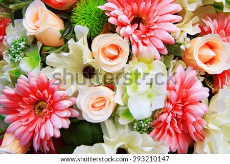 A bouquet of mixed pink flowers including roses, lilies and chrysanthemums with white gypsophila.