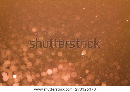 Warm tone background of defocused glittering lights and sparks