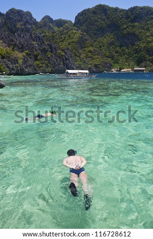 Snorkeling man in clear sea, Palawan, Philippines.