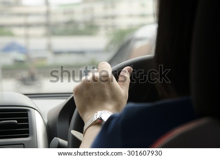 hand of lady driving the car back view