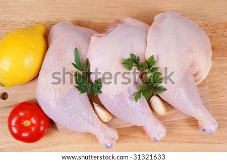 three chicken leg and vegetables on background
